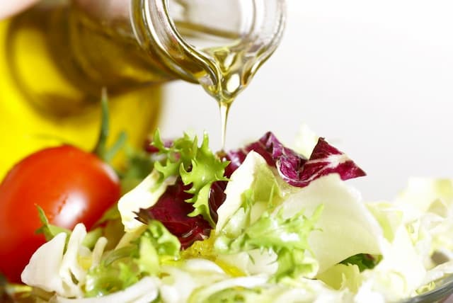 Trộn dầu oliu cùng salad trong những bữa ăn thường ngày